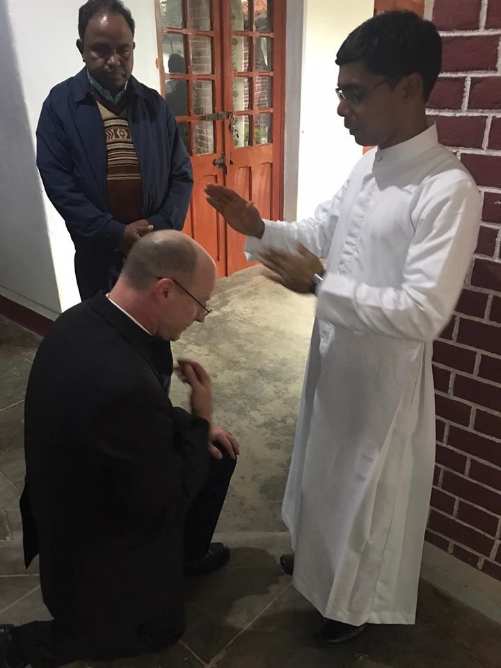 Bishop McKnight receives a blessing from a newly ordained priest on Jan. 4, after presiding at an Ordination Mass in Kunkuri.